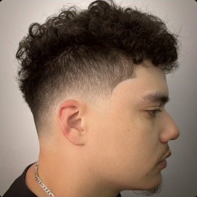 Textured curls on top with a mid taper